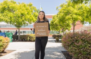Scholar Speaker Olinda Figueredo poses with a sign that says "I'm going to UC Berkeley".