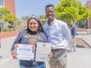 RP Executive Director Christopher Whitmore poses with an RP Scholar who is holding certificates.