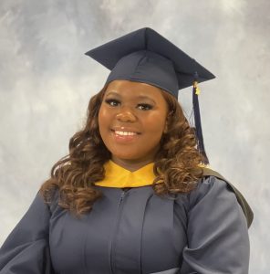 Jaszwan Veal sits for a graduation portrait with cap and gown