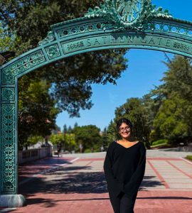 Prathana Adhikari posing in front of Sather Gate at UC Berkeley