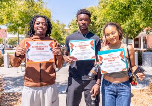 Three students pose for a photo with their Richmond Promise Scholarship certificates during the RP Scholar Celebration on August 3, 2024.