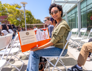 An RP Scholar poses for a photo with their certificate while sitting at the 2024 RP Scholar Celebration.