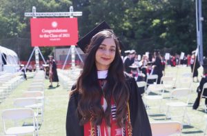Mahi Taban takes a photo wearing cap and gown at her graduation from Clark University