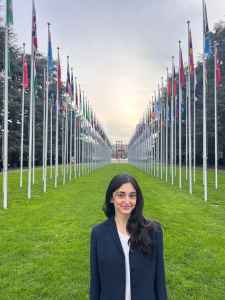 Mahi Taban poses for a photo while standing in front of a row of flags outside the United Nations in Geneva, Switzerland