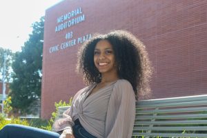 Chandani Battle poses for a photo while sitting on a bench outside the Richmond Memorial Auditorium