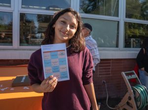 A new Richmond Promise Scholar holds their scavenger hunt card up for a photo at the 2025 Scholar Celebration