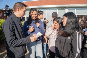 Richmond Vice Mayor Cesar Zepeda signs a scavenger hunt card for new RP Scholars at the 2025 Scholar Celebration