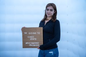A new Richmond Promise Scholar holds a sign that says "I'm Going to Chico State - #RichmondPromise" at RP's 2025 Scholar Celebration.