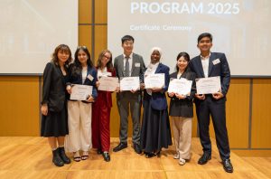Fatoumata Cissé poses for a photo with fellow cohort members and holds a certificate during a ceremony that concluded her 2025 Uniqlo internship.