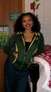 Photo of Jisselle Rodriguez standing in a dorm room wearing a University of Oregon sweatshirt.